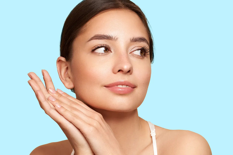 Mina Naji-serum met verpakking op een lichtblauwe achtergrond